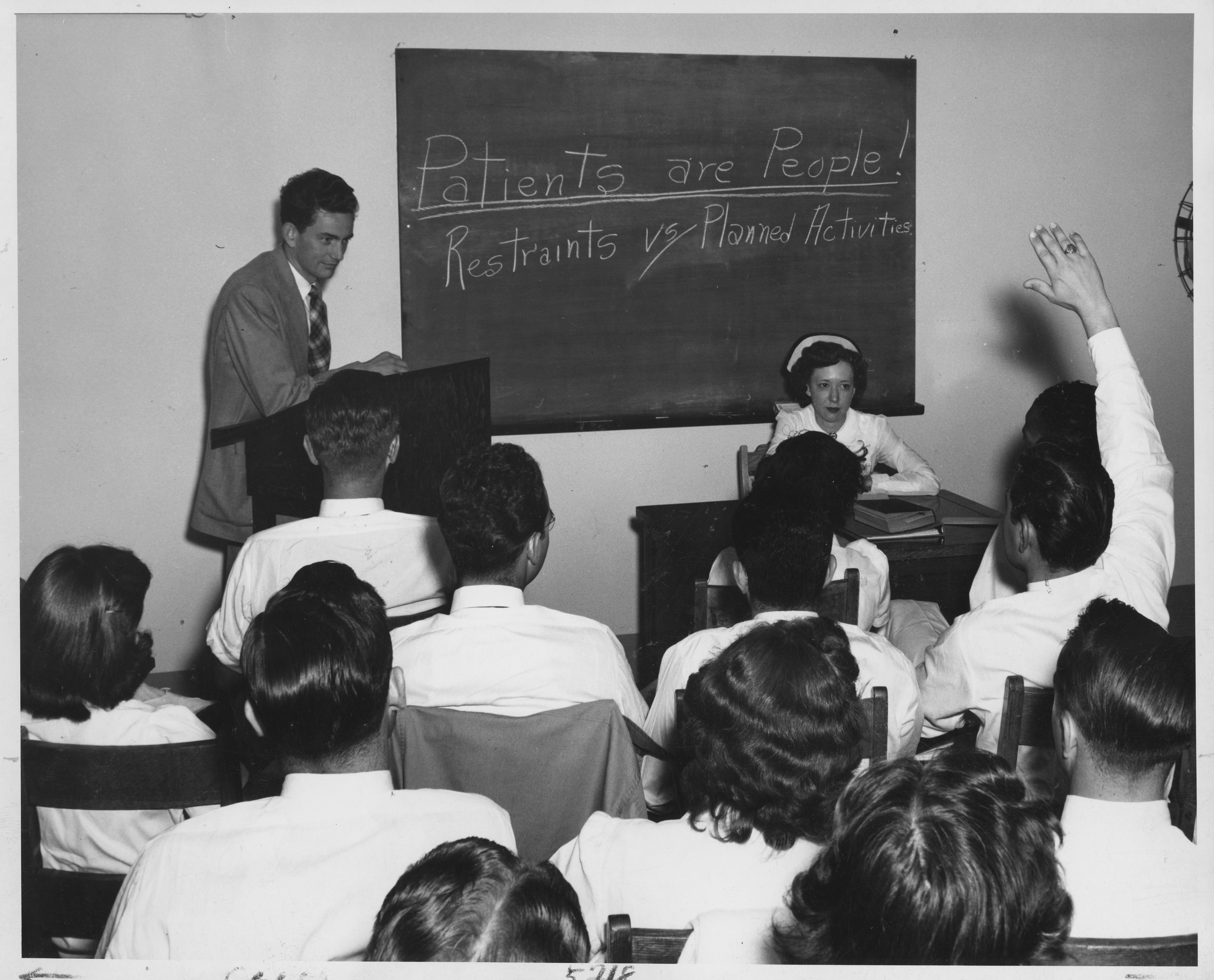 Black and white photo of nurses learning in a classroom