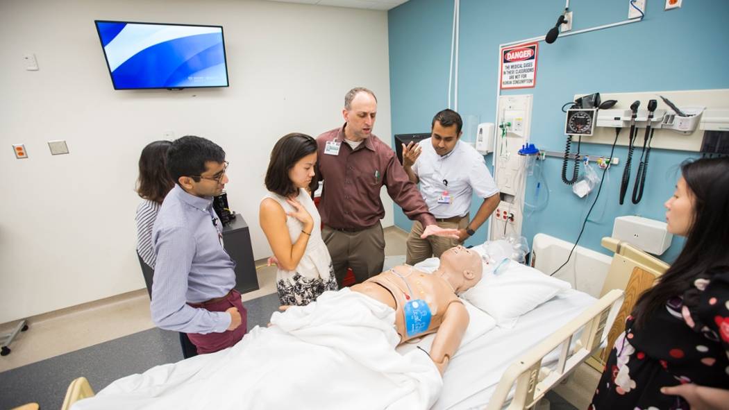 Instructor with students in the Sim Lab