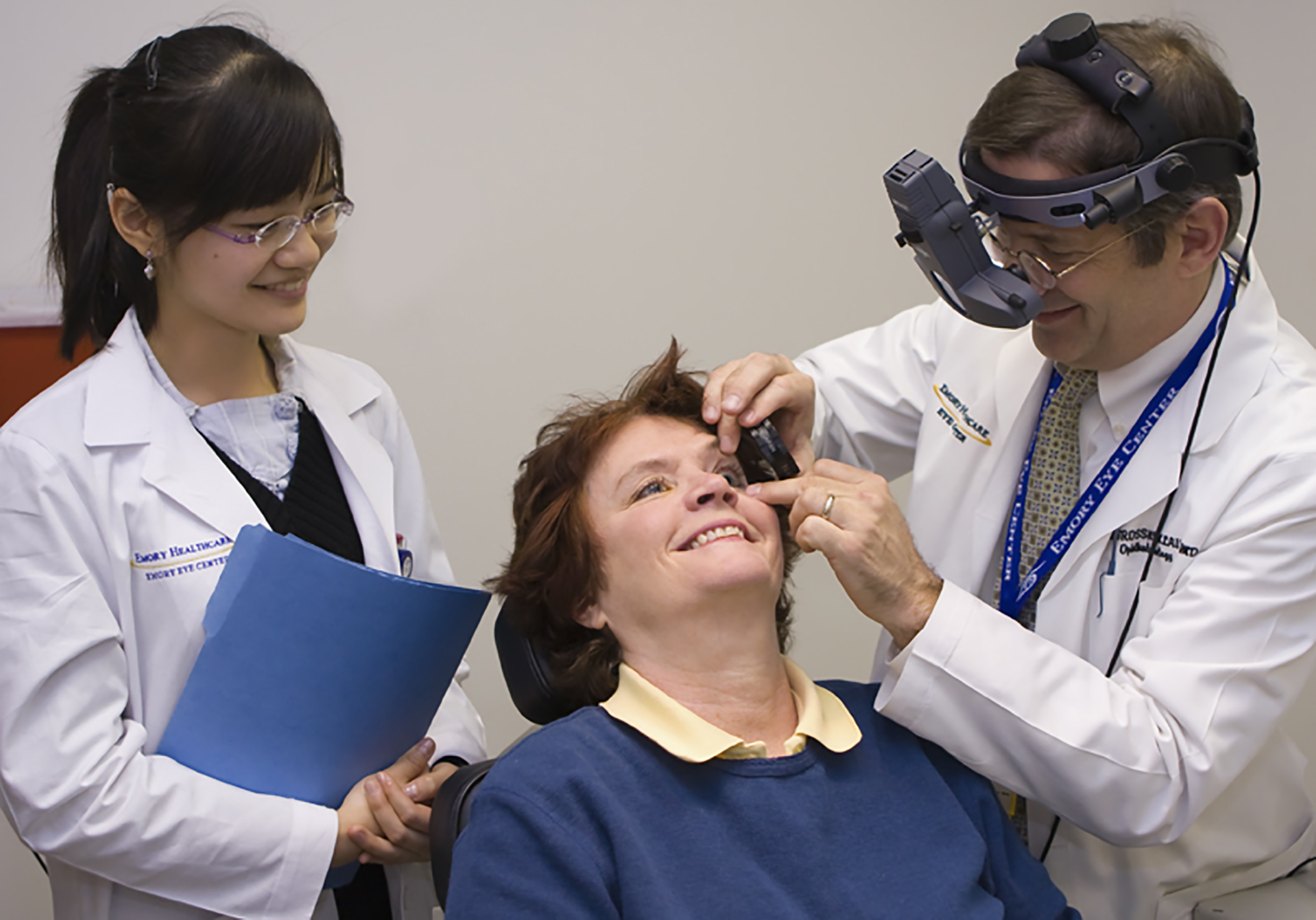 physician and technician doing an eye exam on a seated patient