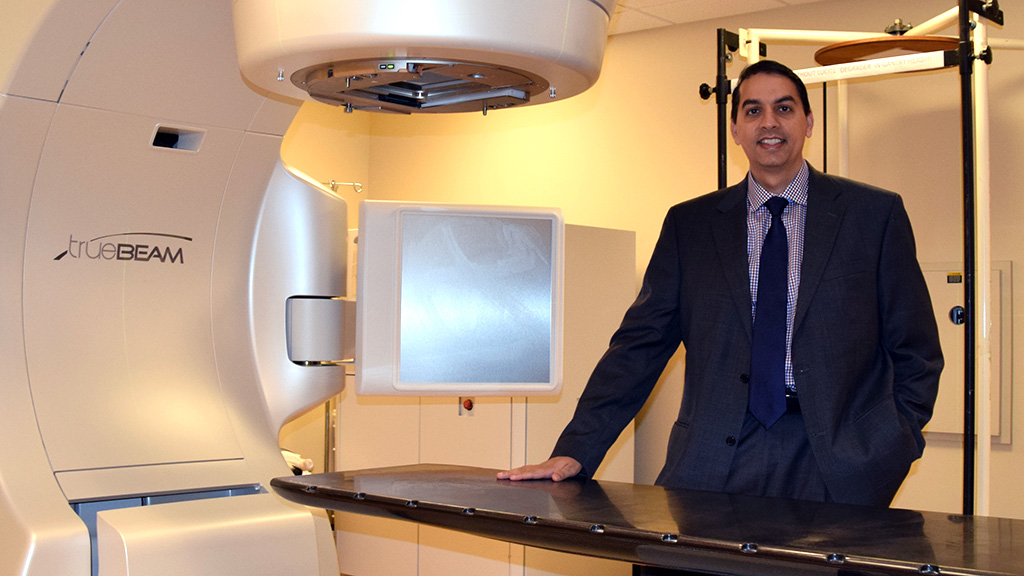 Dr. Mohammad Khan standing in radiation treatment room.