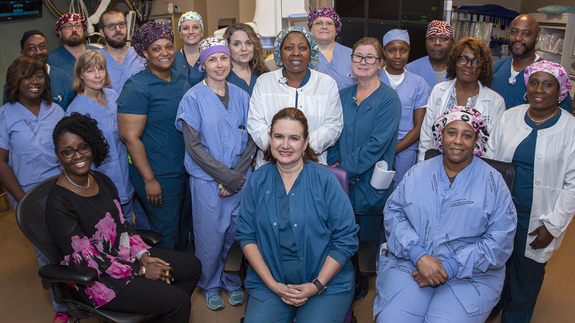 group of men and women wearing colorful surgical hats and blue scrubs