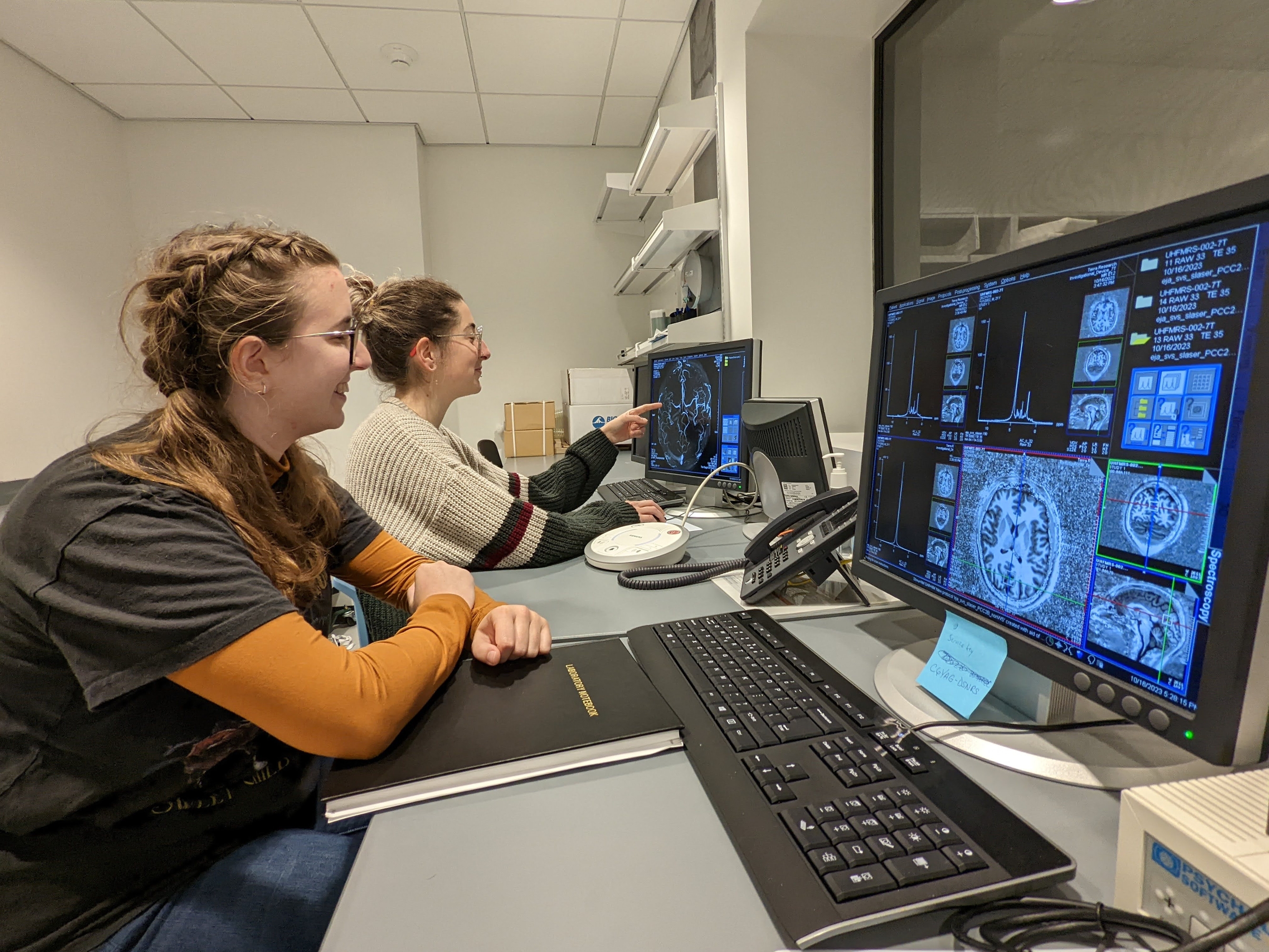 two students look at brain tissue images on large computer screens