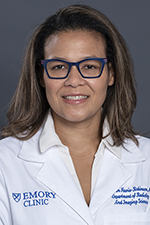 smiling woman wearing glasses and having shoulder length hair and wearing a white lab coat