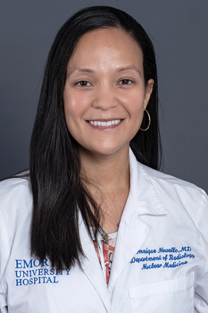 smiling woman with long black hair wearing a white doctor coat with Emory University Hospital embroiderd on front left 