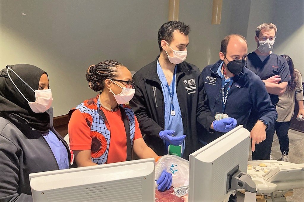 male and female doctors wearing masks looking at computer monitors