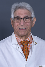 white male with glasses in white coat and orange shirt
